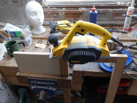 After test fitting, trimmed off a millimetre with an electric plane from the top edge of the front panel frame, for a tight fit.  Side edge butted against a piece of wood to prevent the plane from shredding the end grain.