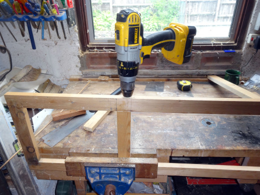 Drilling the holes for dowel jointing the new middle rail in place.
