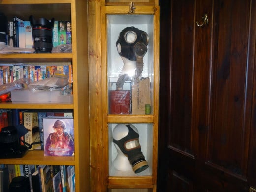 The two gasmasks and other WWII artefacts on display in their display cabinet.