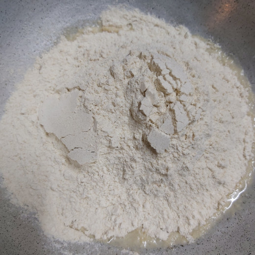 Meanwhile, take 1 cup of wheat flour in a large bowl. Add salt ( or dissolve salt in 2-3 teaspoons of water). Mix well.