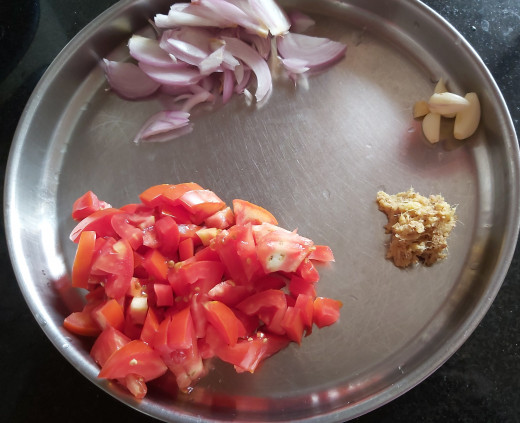 Wash and chop 2-3 medium sized  ripe tomatoes, slice 1-2 onions, peel the skin of 4-5 cloves of garlic and crush ginger. Keep aside.