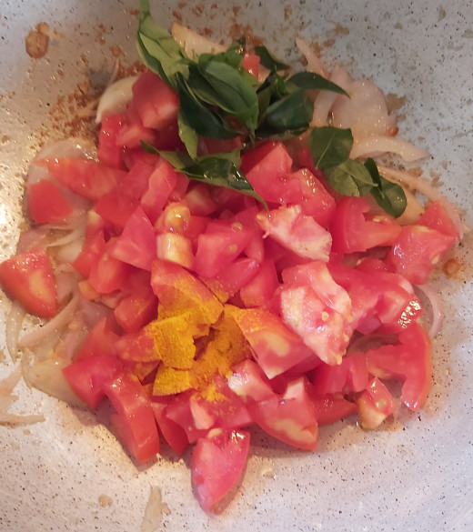 Add chopped tomatoes, 1-2 strings of fresh curry leaves and 1/2 teaspoon of turmeric powder.