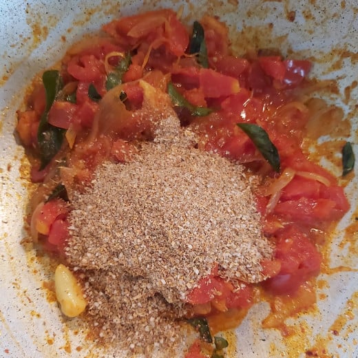 Once the tomatoes are cooked completely add prepared ground spice powder.