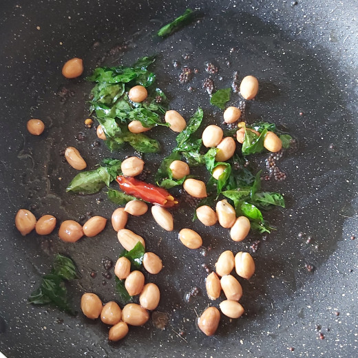 In a frying pan, heat oil, splutter 1/2 teapoon of mustard seeds, 1-2 broken red chilies, 1-2 strings of fresh curry leaves ans 1-2 teaspoons of peanuts. Fry till peanuts turns golden. 