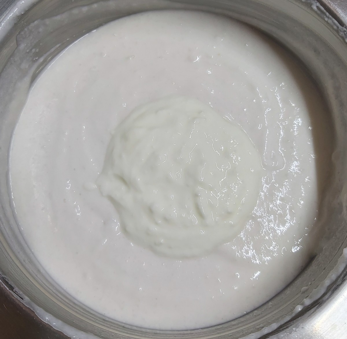 Add 1/4 cup of whisked curd to the batter mixture. Mix, close the lid and keep the batter to ferment for 8-9 hours or overnight.