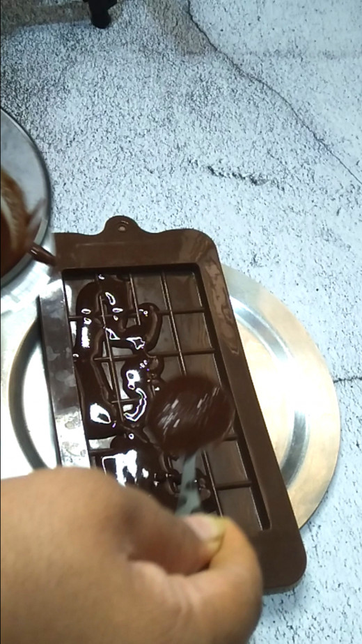 Allow the mixture to cool a little bit and then transfer it on the silicon chocolate bar mold