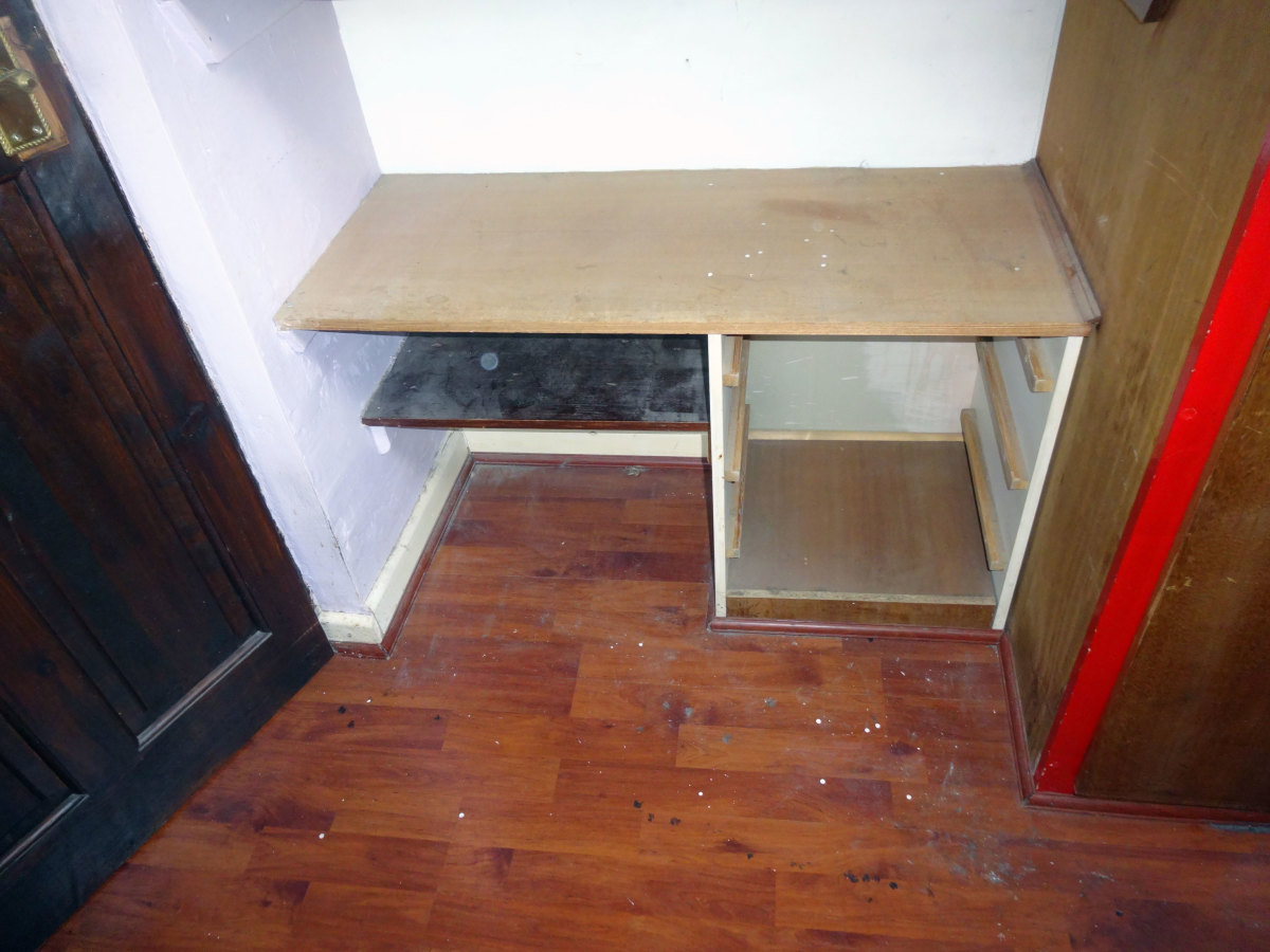 The carcass of the old built-in bedside table, repurposed in the alcove, was fitted before the laminate floor. Therefore, in removing this cupboard means adding a new section of laminate flooring