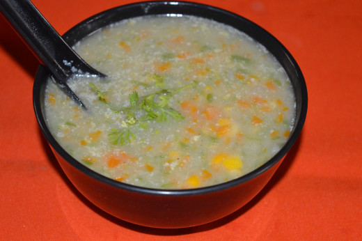 Add hot soup into serving bowls. Garnish it with chopped coriander leaves. Enjoy sipping hot sweet corn vegetable soup! 