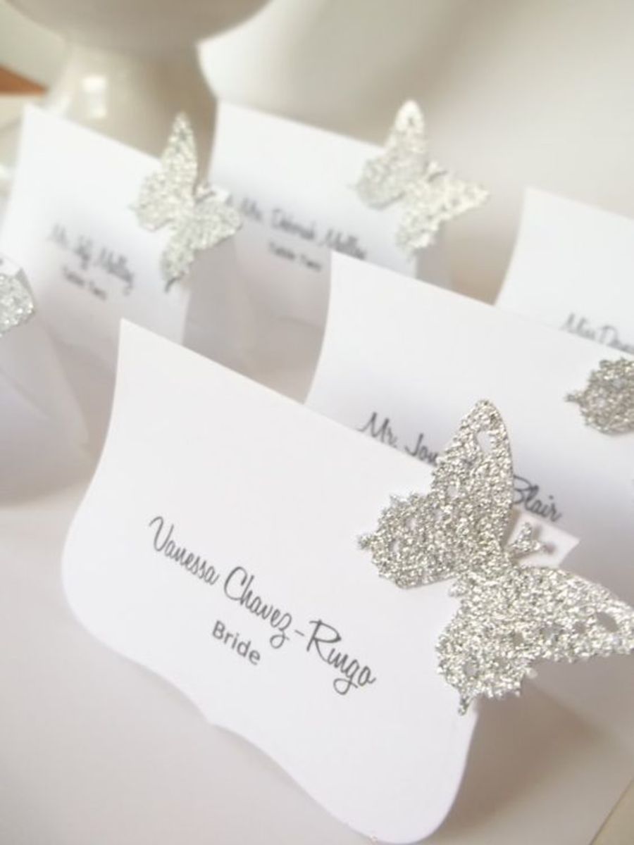 You can add some clam to your place cards by adding glitter butterflies to them, Just cut out some butterflies and add some glue and cover with fine glitter, 