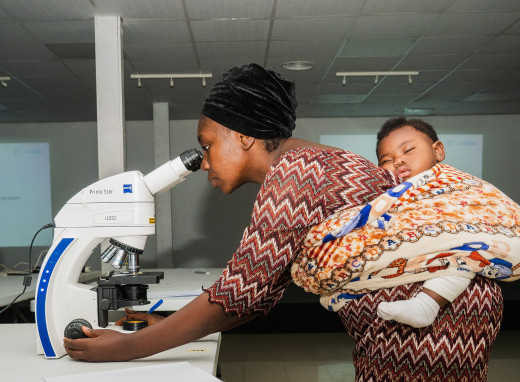 A laboratory scientist in Nigeria with her young baby attending malaria microscopy training conducted by eHealth Africa/EHA Clinics.