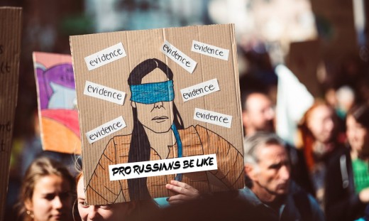 A group of protesters holding a cardboard with an anti-Russian message (a sketch of a blindfolded person ignoring all the evidence) - Photo by Markus Spiske on Pexels. Edits by the author.