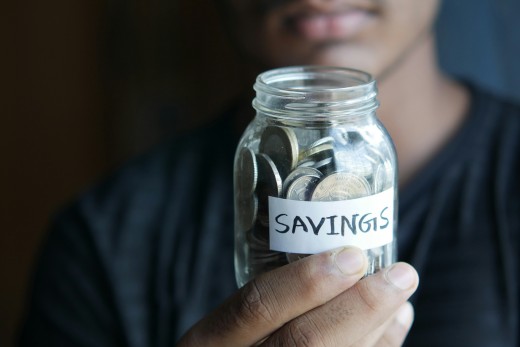 A man holding a jar with a savings label on it, photo by Towfiqu barbhuiya on Unsplash