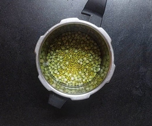 Once well soaked, drain off. Transfer the soaked green gram to the cooker. Add 1/2 cup sprouted green peas, 1 cup of water, salt, close the lid and take 2 whistles.