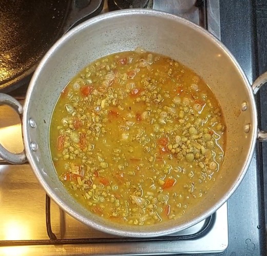 Add cooked green gram and peas along with water, add 1/2 cup more water, mix well.