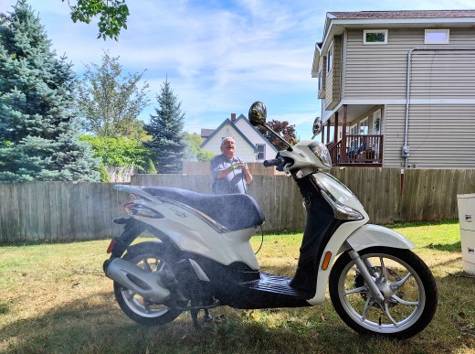 My friend is washing the scooter