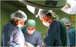 Plastic surgeons doing abdominoplasty (tummy tuck) on a patient.