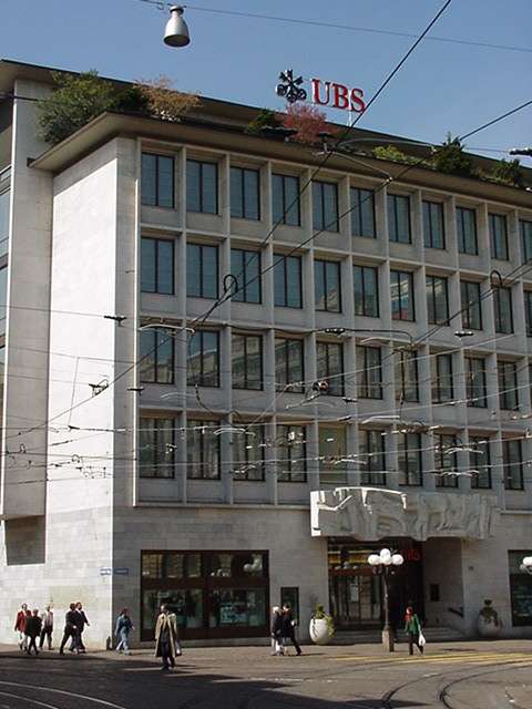 UBS, the Swiss bank. The electric wires that you see here are for the trams. There is also a tram stop in front of the UBS 
