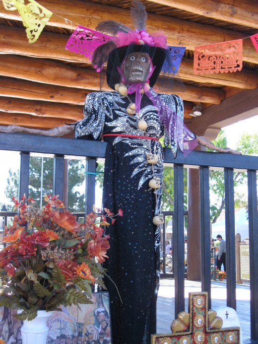 Skeleton overlooking El Dia de los Muertos celebration in plaza in La Mesilla, NM