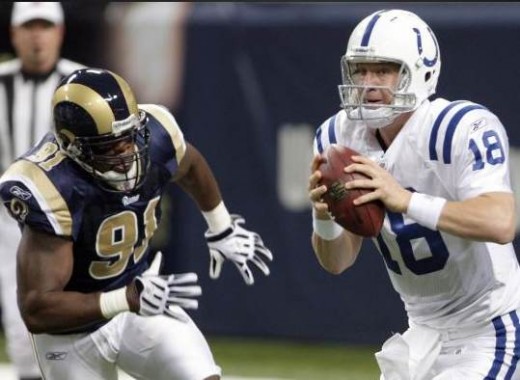 Indianapolis Colts quarterback Peyton Manning, right, drops back to pass under pressure from St. Louis Rams defensive end Leonard Little, left, during the first quarter of an NFL football game Sunday, Oct. 25, 2009, in St. Louis. (AP Photo/Seth Perlm