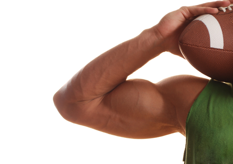 large male bicep muscle with hand holding football