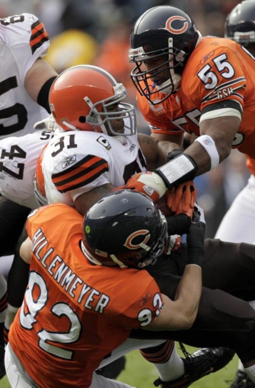 Cleveland Browns running back Jamal Lewis (31) is tackled by Chicago Bears linebackers Hunter Hillenmeyer (92) and Lance Briggs (55) in the first quarter of an NFL football game in Chicago, 11/01/09 (AP Photo/Kiichiro Sato)