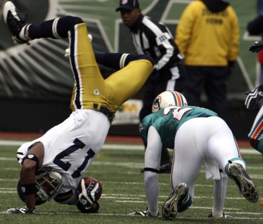 New York Jets wide receiver Braylon Edwards (17) flips over Miami Dolphins cornerback Sean Smith (24) while carrying the ball during the first quarter of an NFL football game at Giants Stadium in East Rutherford, N.J., Sunday, Nov. 1, 2009. (AP Photo