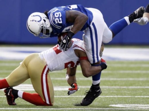 Indianapolis Colts running back Joseph Addai, top, is tackled by San Francisco 49ers cornerback Nate Clements in the second quarter of an NFL football game in Indianapolis, Sunday, Nov. 1, 2009. (AP Photo/Michael Conroy)