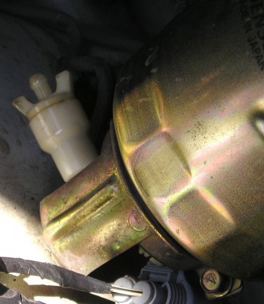 Close up of fuel filter showing white valve which is released to allow water to leak out of the unit.  Photo by Glendon Caballero.