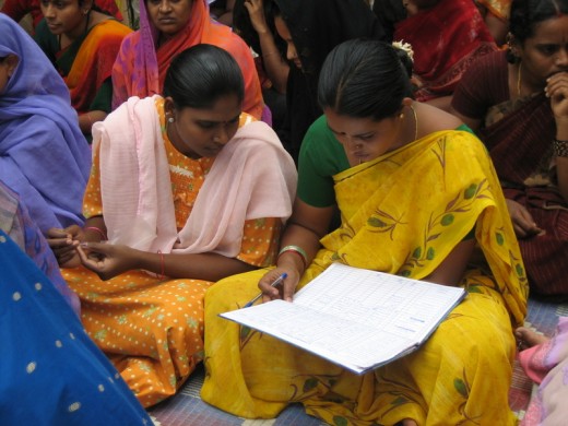 Microfinance loan clients in India check their books.