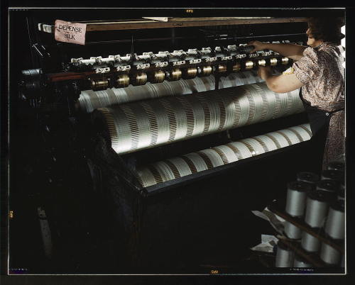 Before machine guarding - a messy accident waiting to happen.  Note the apron that can catch and drag her into the machine.
