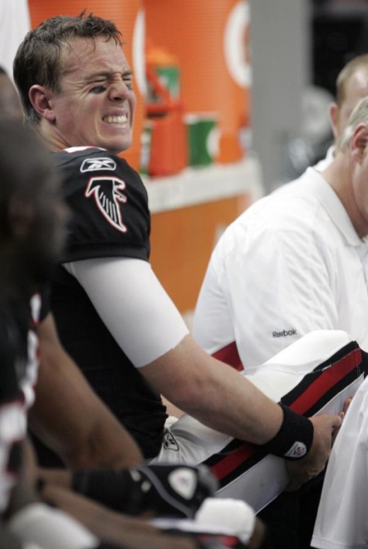 Atlanta Falcons quarterback Matt Ryan, left, reacts as training staff attend to his injured foot in the first quarter of an NFL football game against the Tampa Bay Bucaneers in Atlanta, Sunday, Nov. 29, 2009. (AP Photo/John Bazemore)