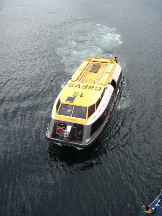 A lifeboat in the water ferrying passengers