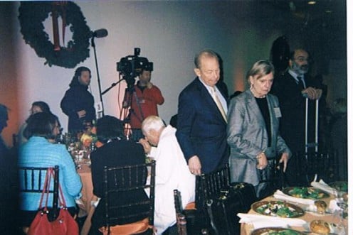 An image of Abe and Irene Pollin as they reach their designated spots at a luncheon table.