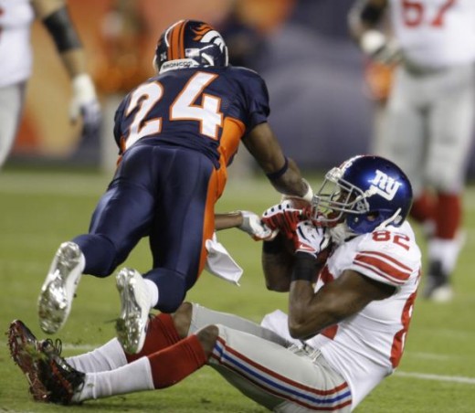 Denver Broncos cornerback Champ Bailey (24) tackles New York Giants wide receiver Mario Manningham (82) during an NFL football game in Denver, Thursday, Nov. 26, 2009. (AP Photo/Darron Cummings)
