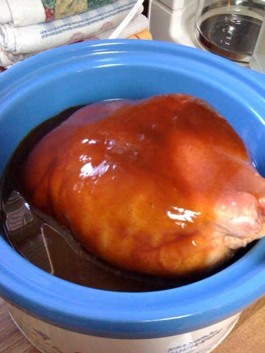 Pour the entire bottle of BBQ sauce over the chicken. I added about one bottle of water to the mixture.