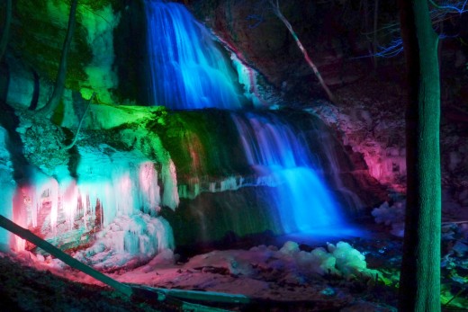 Sherman Falls in Hamilton at night under colored spotlights.