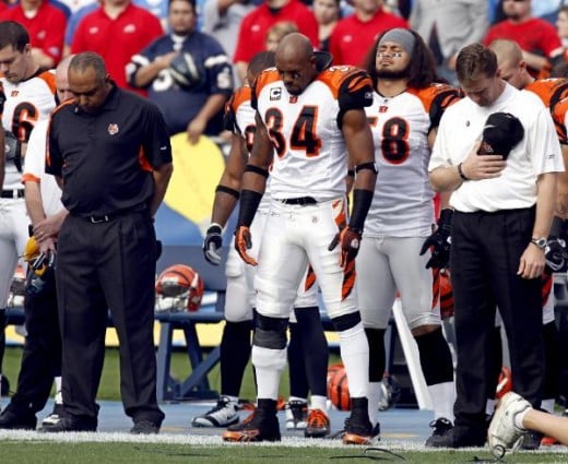 Cincinnati Bengals coach Marvin Lewis, left, and players including Kyries Hebert (34) and Rey Maualuga (58) observe a moment of silence for deceased player Chris Henry before the NFL football game against the San Diego Chargers on Sunday, Dec. 20, 20