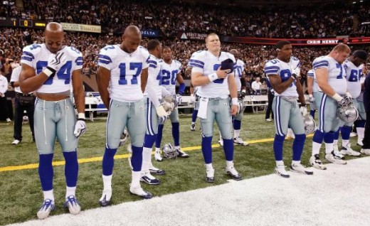 Members of the Dallas Cowboys observe a moment of silence in tribute to former Cincinnati Bengals player Chris Henry before playing against the New Orleans Saints at the Louisiana Superdome in New Orleans, Louisiana on December 19, 2009. (Joe Robbins