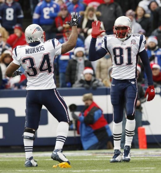 New England Patriots' Randy Moss (81) celebrates a pass interference call with Patriots' Sammy Morris (34) during the first half of the NFL football game in Orchard Park, N.Y., Sunday, Dec. 20, 2009. The Bills were penalized on the play. (AP Photo/ D