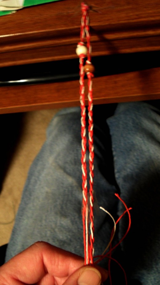 after securing each bead in to position with the second square knot braid each group of strands until the length from the taped knot to the end of the braiding reaches near 7 1/2" 