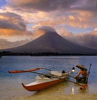 The solace and idyllic view of the Mayon Volcano. A traditional boat here provides a lovely and artistic scene.