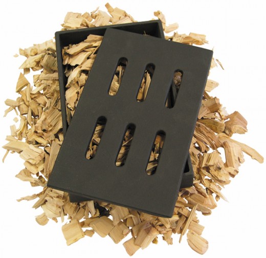 Cast iron wood smoker sits under the cooking grates and adds a wood burning smokey flavor to grilled cooking.