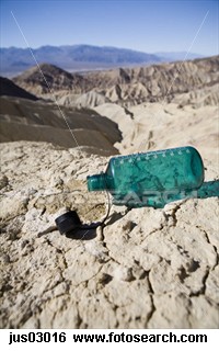 Empty water bottle in desert 