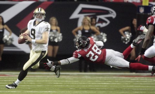 New Orleans Saints quarterback Drew Brees (9) outruns the defense of Atlanta Falcons Thomas DeCoud (28) in the first half of an NFL football game in Atlanta, Sunday, Dec. 13, 2009. (AP Photo/Dave Martin)