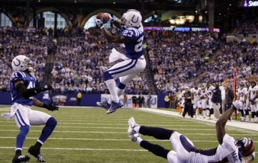 Indianapolis Colts safety Tim Jennings, center, intercepts a pass intended for Denver Broncos wide receiver Brandon Marshall, right, in the third quarter of an NFL football game in Indianapolis, Sunday, Dec. 13, 2009. Antoine Bethea of the Colts is a