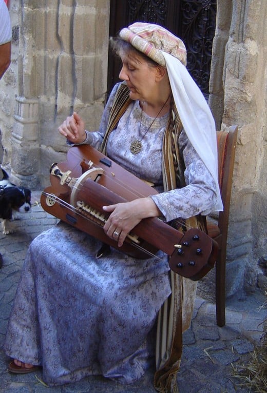 A local lady demonstrating a mediaeval musical instrument in the streets of Rochechoaurt.
