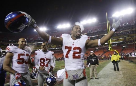 New York Giants' Osi Umenyiora (72) celebrates with teammates Bryan Kehl (53) and Domenik Hixon (87) after after the Giants defeated the Washington Redskins 45-12 in an NFL football game, Monday, Dec. 21, 2009, in Landover, Md. (AP Photo/Rob Carr)