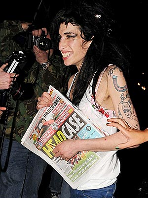 The talented but troubled Amy Winehouse picking up a paper during a week of reports of new drug use