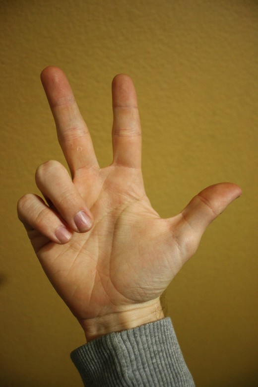 Index and middle fingers and thumb are extended.