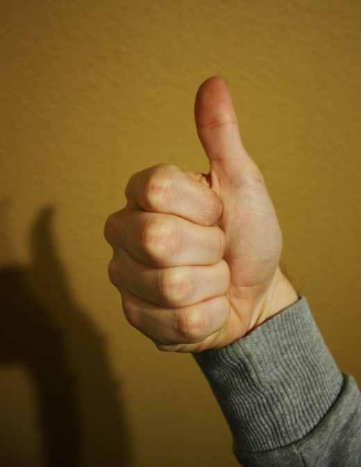 All fingers pulled into the palm and the thumb is extended. The hand is shook right to left.